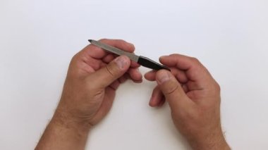 Erkek elleri metal bir tırnak törpüsü gösterir. 