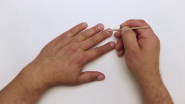 Turuncu çubuğu yakın çekim ile parmağın tırnağını nazikçe hareket ettirir..
