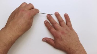 Erkekler, orta parmağındaki çiviyi nazikçe metal bir dosya ile işlerler.. 