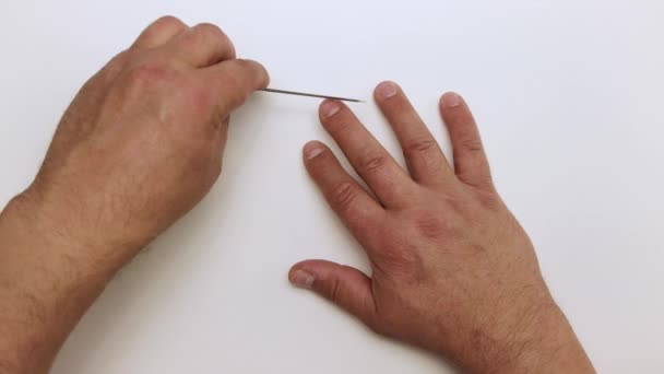 Heren handen voorzichtig verwerken van de nagel op de middelvinger met een metalen bestand. — Stockvideo