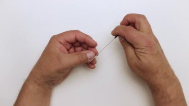 Adam elinde metal bir dosya ile küçük resmi nazikçe işliyor.. 