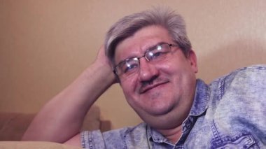 Mutlu, gevşemiş adam koltuğa uzanmış, kahkahalarla.,