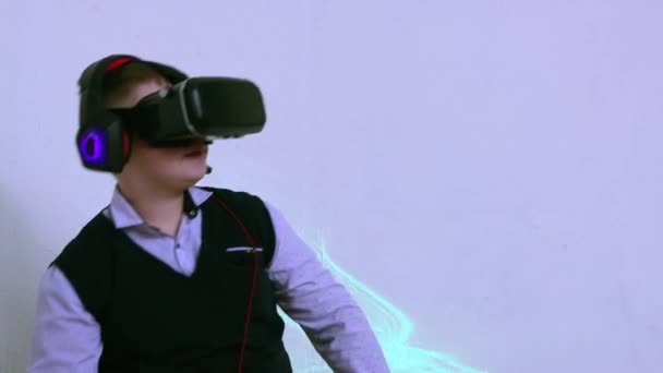 Happy boy in augmented reality headset en koptelefoon speelt en ontwijkt. — Stockvideo