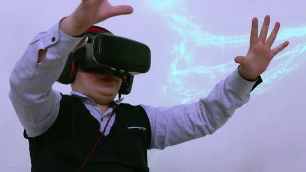 A boy in an augmented reality headset and headphones plays smoothly in space. — Stock Video