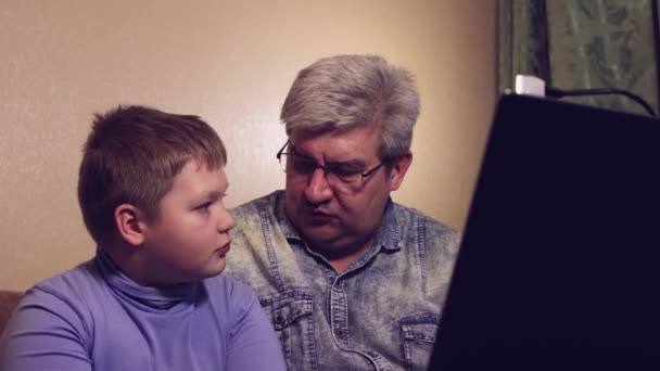 Colegial niño estudiando en línea desde casa papá ayuda al niño. — Vídeos de Stock