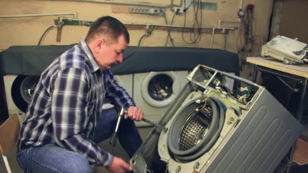 En Kvkaz manlig specialist demonterar en tvättmaskin — Stockvideo