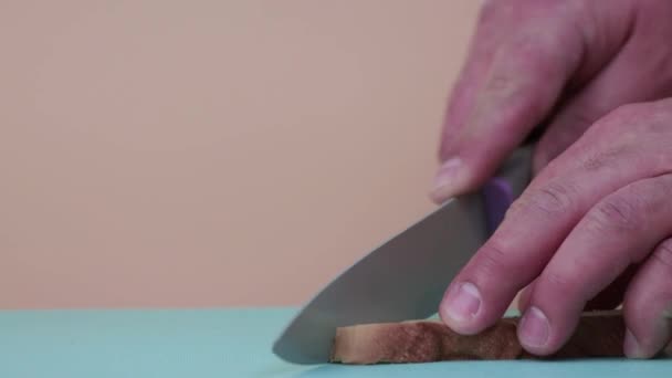 Primer plano manos masculinas cortar pan blanco en rodajas. — Vídeo de stock