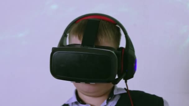 Jongen in augmented reality headset kijken naar de camera is dansen en glimlachen. — Stockvideo