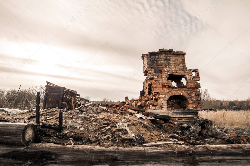 A destroyed heating stove standing alone in a vacant lot.