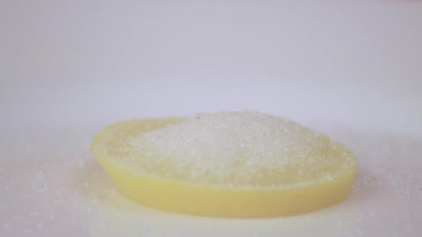 Κοντινό πλάνο πασπαλίζουμε με αλεσμένο μαύρο καφέ κίτρινο λεμόνι σε λευκό πιάτο. — Αρχείο Βίντεο