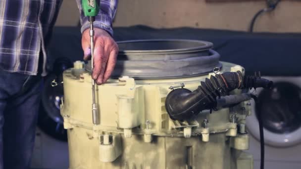 The man tightens the bolts of the washing machine drum. — Stock Video