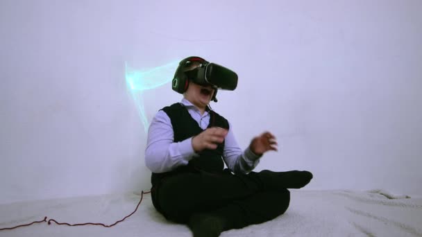 A boy in augmented reality glasses laughs and shakes his hands. — Stock Video