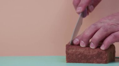 Erkek elleri yavaş çekimde siyah ekmek kesiyor..