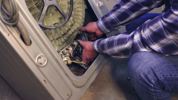 Ein Fachmann holt den Elektromotor aus der Waschmaschine. — Stockvideo