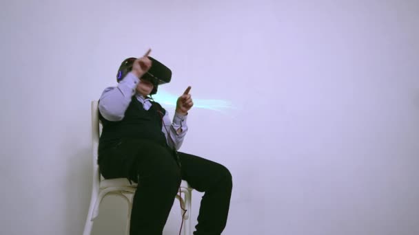 A boy in augmented reality glasses sits and pokes his fingers in space. — Stock Video