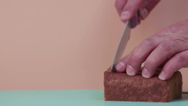Close-up mannelijke handen gesneden zwart brood in slow motion. — Stockvideo