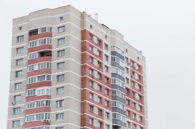 Kırmızı tuğladan balkonları olan yüksek katlı bir bina.. 