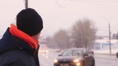 Bir iş adamı şehrin arka planında durur ve gülümser..