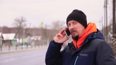 Dorgi 'nin kenarındaki bir iş adamı telefonla konuşuyor ve gülümsüyor..