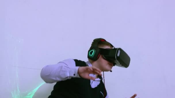 Un niño en un casco de realidad aumentada juega y esquiva amenazas virtuales. — Vídeos de Stock