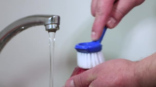 Yakın çekim erkek elleri, akan suyun altında bir fırça ve sabunla bir nar yıkar. — Stok video