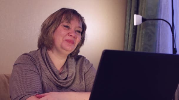 Fiatal nő konferenciahívásokat tart laptopon, beszél, otthonról dolgozik. — Stock videók