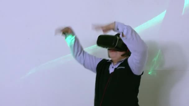 The boy in the augmented reality helmet dances cheerfully, waves his arms — Stock Video