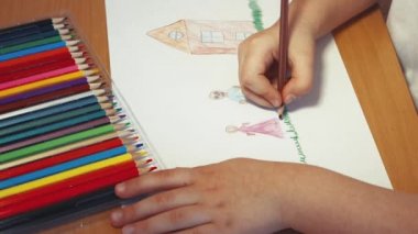 Çocukların elleri evin yakınına kurşun kalemle bir aile çizer..