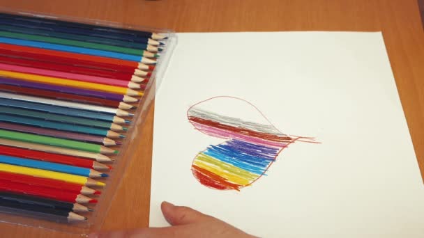 Corazón del arco iris dibujar manos de los niños con un primer plano lápiz. — Vídeos de Stock