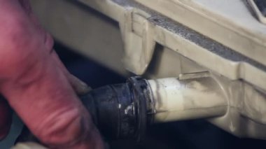 Adam lastik bir hortum takar ve güvenlik için bir kelepçe takar..