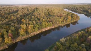 Orman üzerinde yüksek uçuş ve günbatımında sakin nehir.