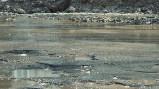 泥だらけの水たまり、穴や亀裂と悪い道路上の車の運転を閉じる. — ストック動画