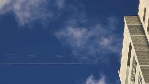 Modrá obloha a rychle bílé kumulativní mraky nad střechou domu. — Stock video