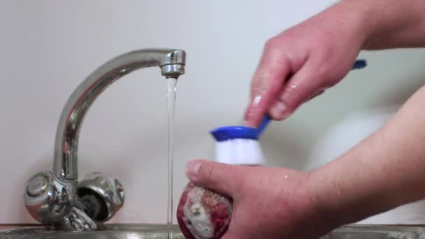 Крупним планом чоловічі руки миють гранат під проточною водою в повільному русі . — стокове відео