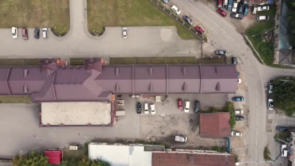 Vista aérea de una calle de la ciudad con árboles verdes, casas y coches de pie. — Vídeos de Stock