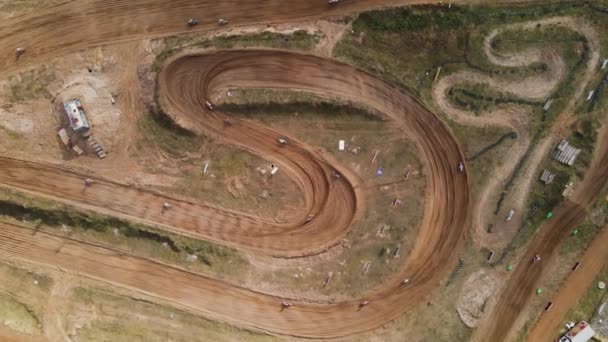 Voe sobre as mudanças de motocross em movimento rápido ao longo de uma pista sinuosa. — Vídeo de Stock