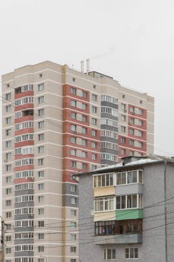 Modern bir gökdelenin arka planında eski gri bir ev.. 