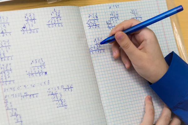 A girls hand with a ballpoint pen writes in bad handwriting close-up. Stock Image