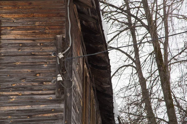 Electrical insulators and wires on the wall of an old planked building. — Stock Photo, Image