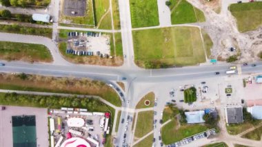 Hareket halindeki arabalar ve park yerleriyle dolu bir banliyö kavşağının üzerinden uçmak.