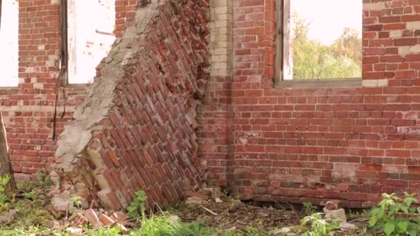 Destroyed red brick wall with window openings and an arch — Stock Video