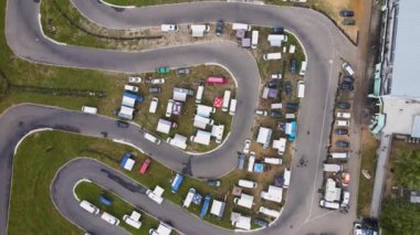 Yeşil kaldırımlı ve arabalı dolambaçlı bir yolda insansız hava aracı rotasyonu..