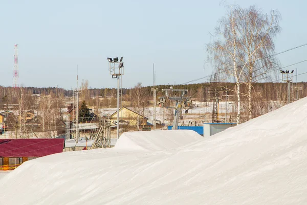 Kayak merkezi, yapay ışıklandırma kuleleri ve ağaçları olan yumuşak kar yamacı..