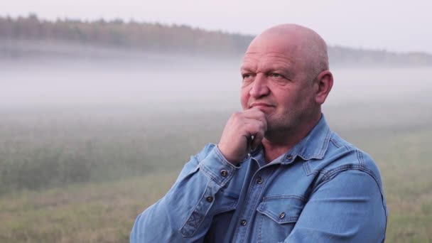 Een man in close-up staat gepensioneerd in de mist — Stockvideo