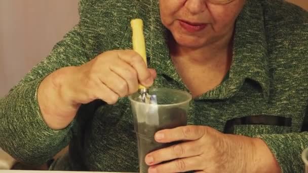 En kvinna gör ett hål med en spatel i en kruka kompost, lägger gödsel — Stockvideo