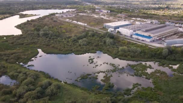 Vista desde un quadcopter a campos verdes, lagos y una zona industrial. — Vídeos de Stock