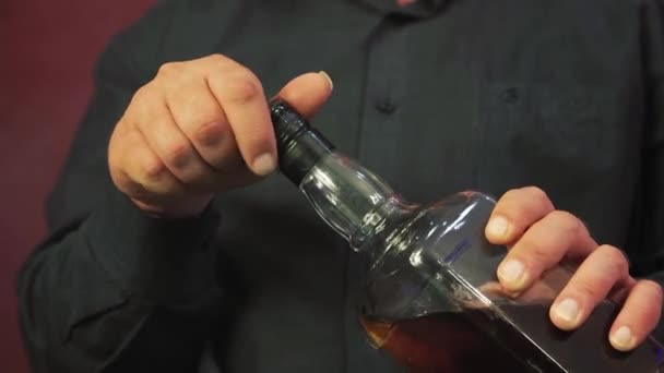 Ein riskanter Pokerspieler öffnet während eines Kartenspiels eine Flasche Whiskey. — Stockvideo