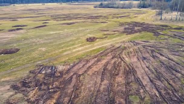 Vol rapide au-dessus de tas épars de fumier dans un champ agricole. — Video