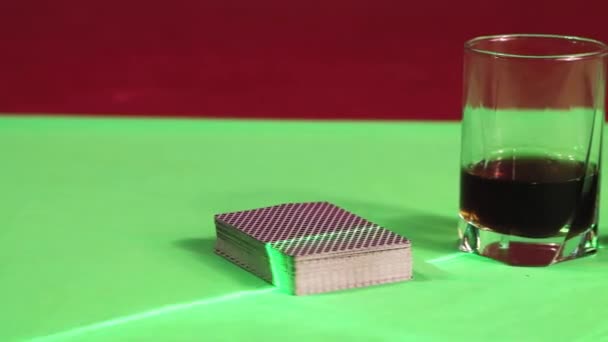 Auf dem Spieltisch liegen Karten, Chips, ein Glas Whiskey und Gläser auf einer Maske. — Stockvideo
