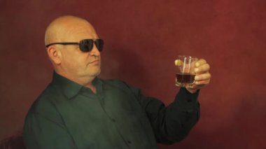 Oyun sırasında riskli bir kumarbaz bir bardak viskiyi yakından inceler.. 